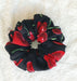 Black scrunchie with red and green floral pattern on a white background